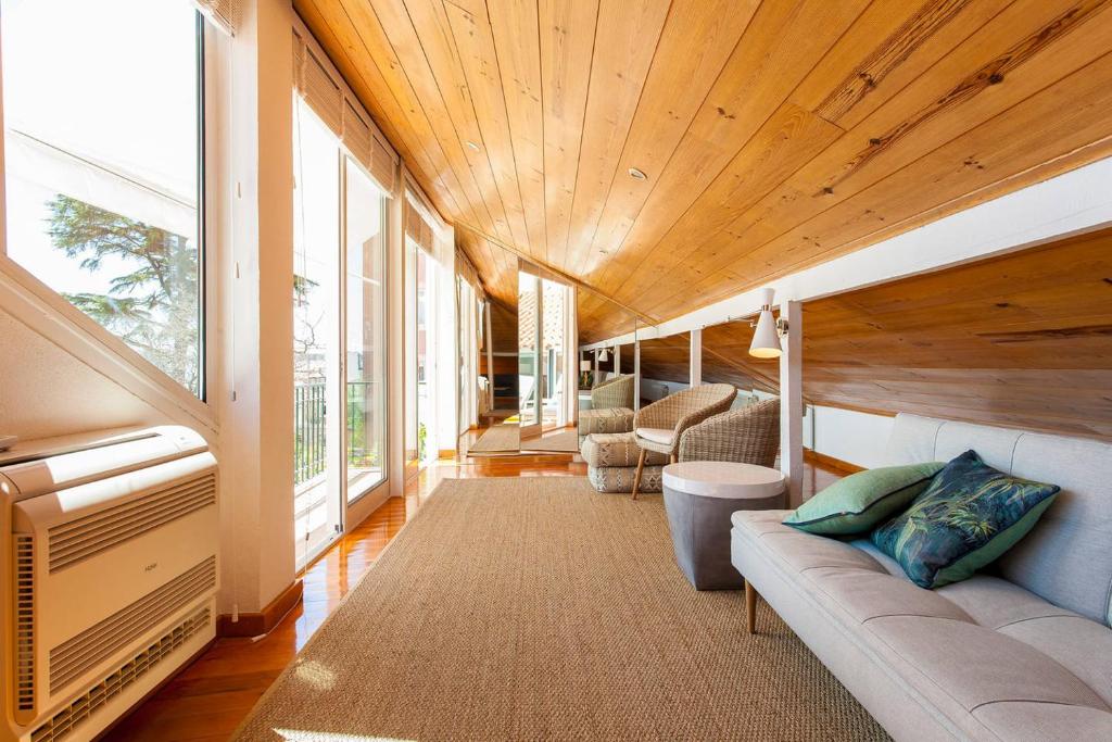 a living room with a couch and some windows at Santos River View Terrace Duplex in Lisbon