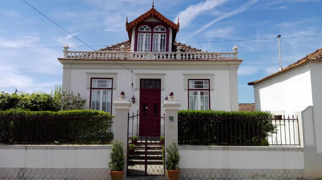 a white house with a red door at Vila Delfina in Lousã