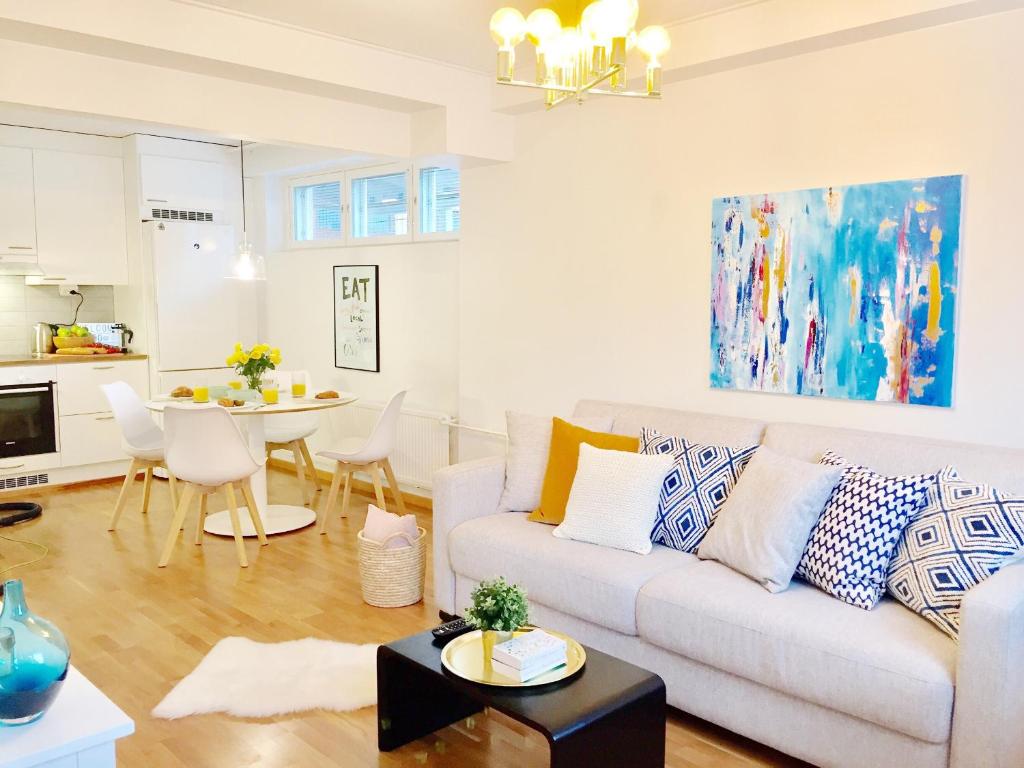 uma sala de estar com um sofá e uma mesa em Lahti Center Design Apartment Uno em Lahti