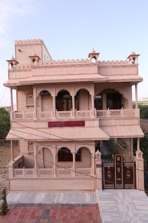 Edificio grande de color rosa con balcón lateral en Harsidhi Haveli, en Bikaner