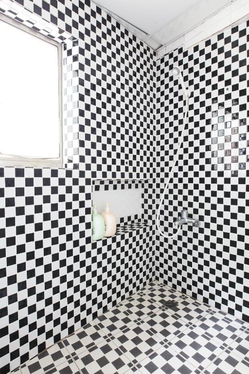 a bathroom with a black and white checkered wall at On My Way Jiufen Youth Hostel in Jiufen
