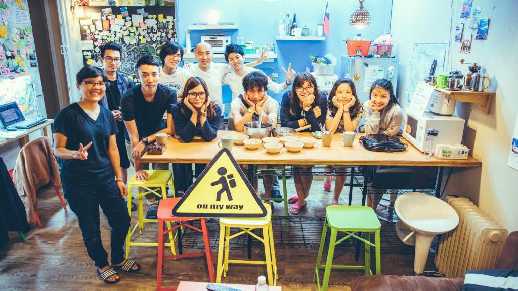 a group of people standing around a table at On My Way Jiufen Youth Hostel in Jiufen