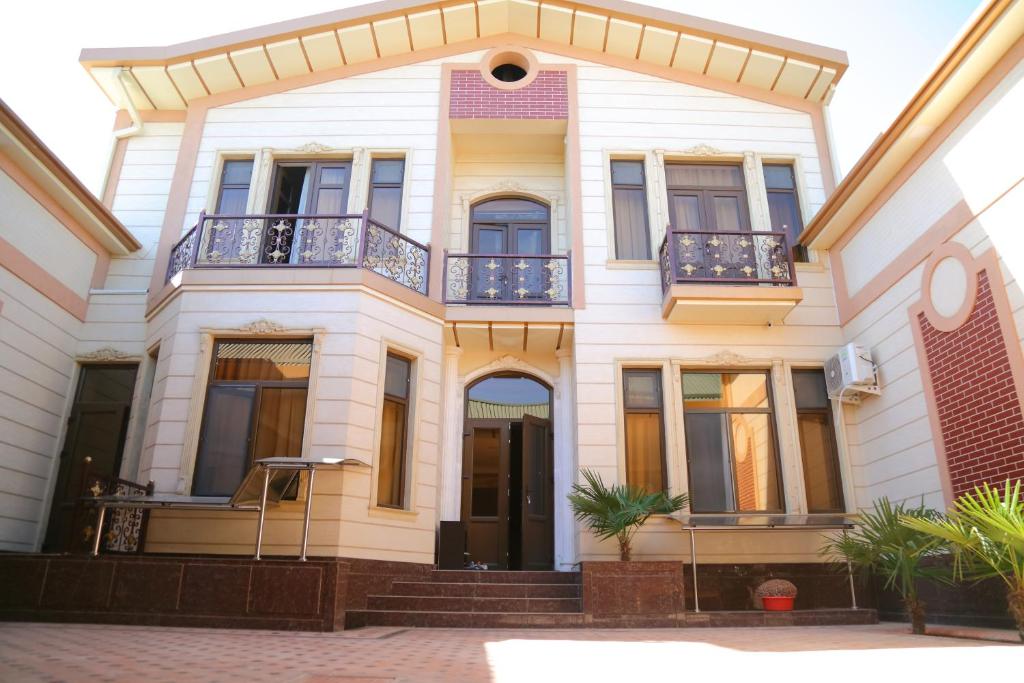 a large white house with a balcony at Muzaffar Hotel Samarkand in Samarkand