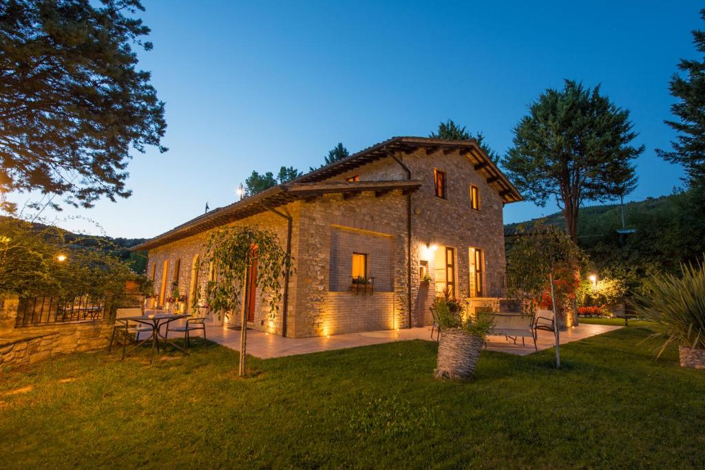 una grande casa in pietra con un cortile di notte di Antica Fonte ad Assisi