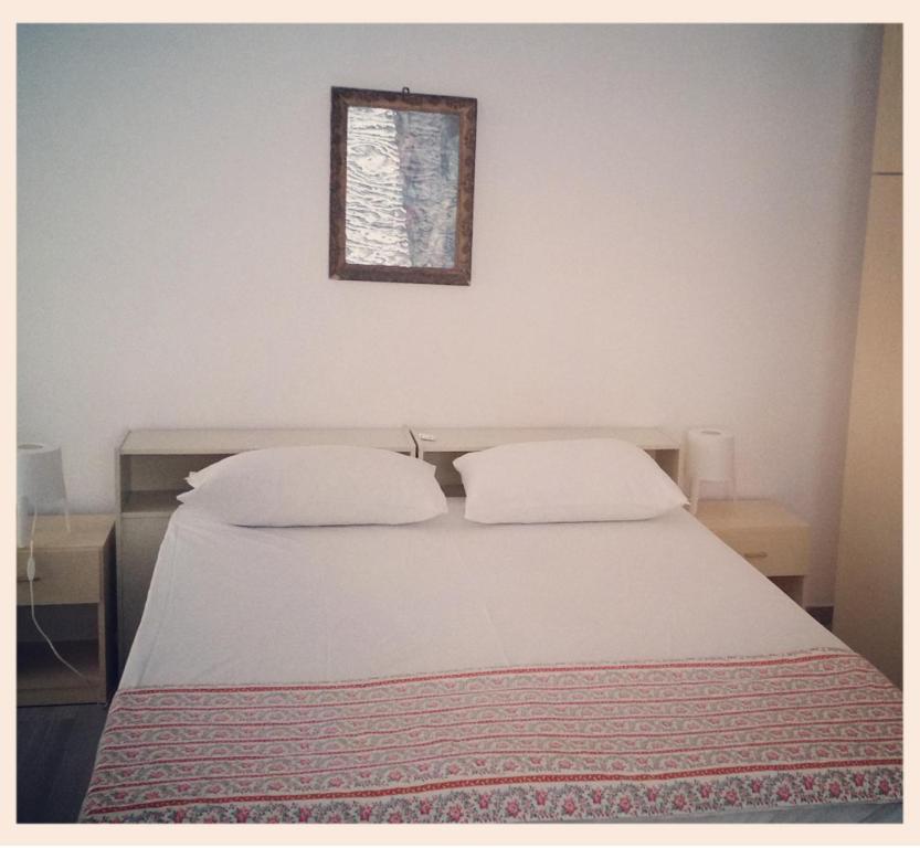 ロゼート・デッリ・アブルッツィにあるRosetoholidaysのベッド1台(枕2つ付)、壁に絵が描かれています。