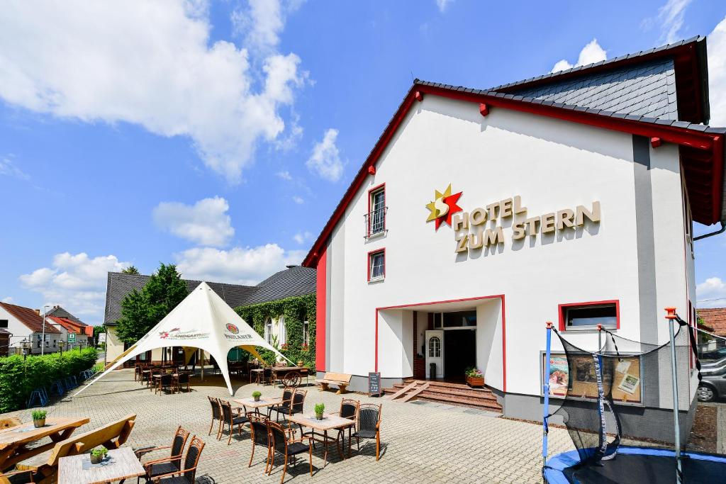 a building with tables and chairs in front of it at Hotel Zum Stern Spreewald in Werben