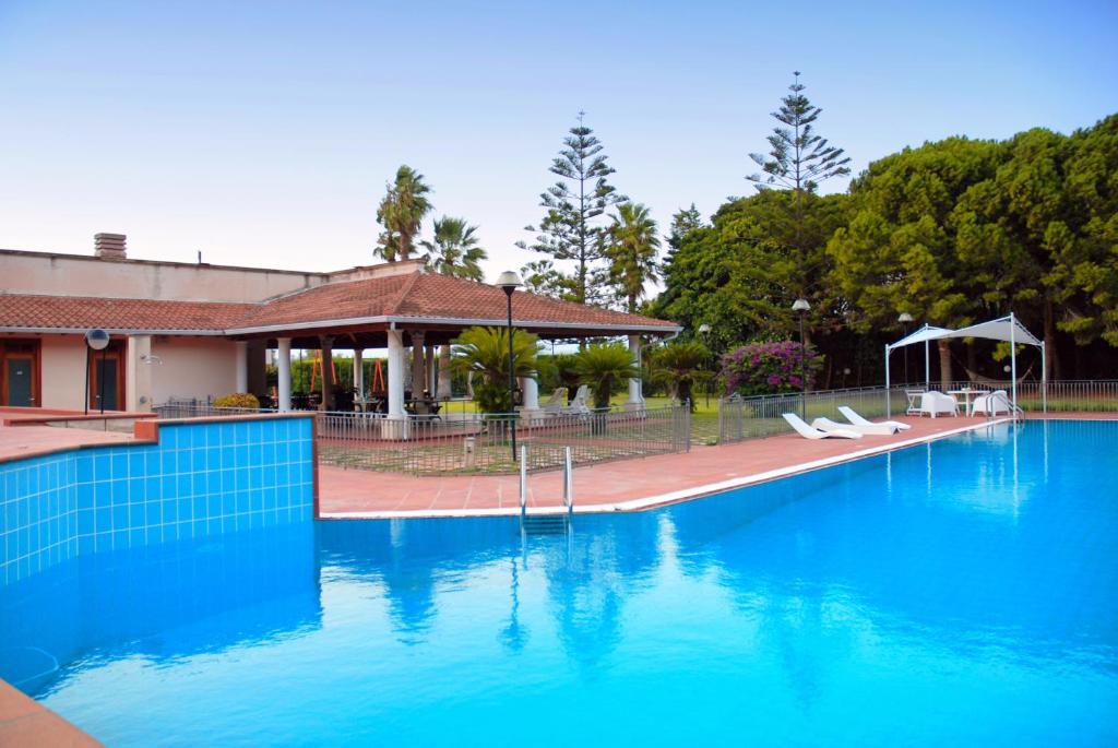 una piscina con acqua blu di fronte a una casa di Villa Sara a Ispica