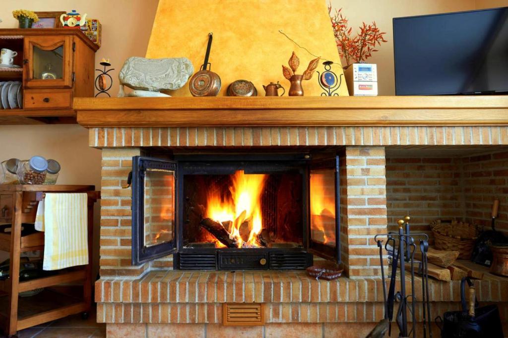a brick fireplace with a fire in it at La Aldaia de Urbasa in Eulate