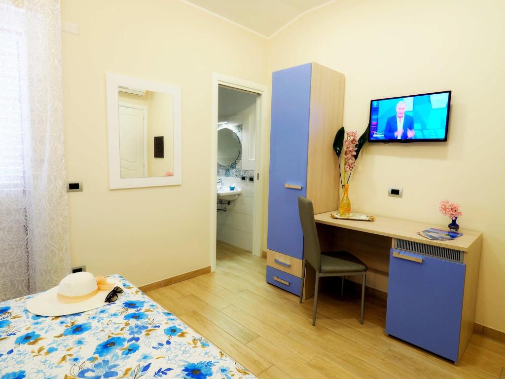 a bedroom with a bed and a desk with a computer at B&B Galatea in Santa Domenica