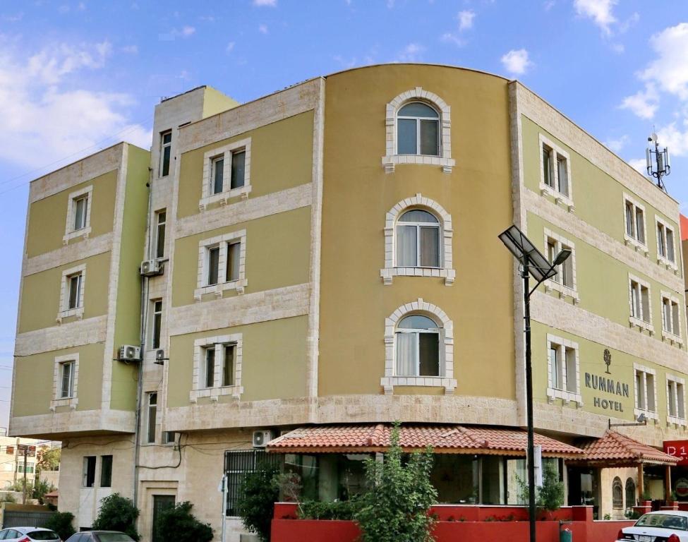 a large building with a red roof and windows at Rumman Hotel in Madaba