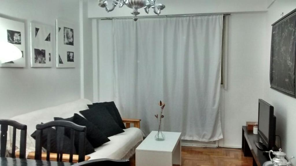 sala de estar con sofá blanco y TV en Apartamento Recoleta en Buenos Aires