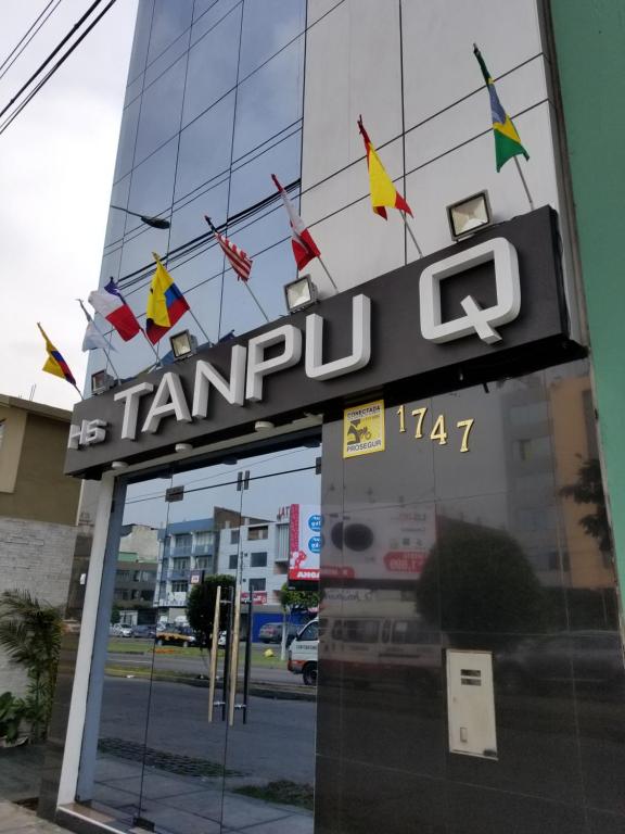 um sinal para um concessionário de carros em frente a um edifício em Imperio Tanpu Q em Lima