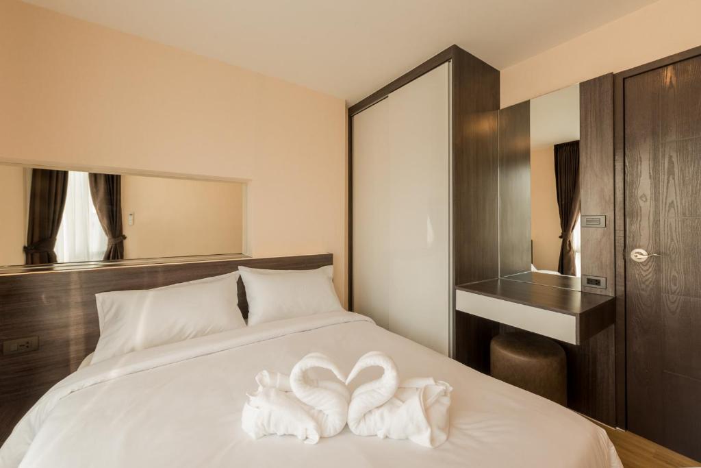 A compact bedroom with a double bed, built-in storage and a dressing desk.