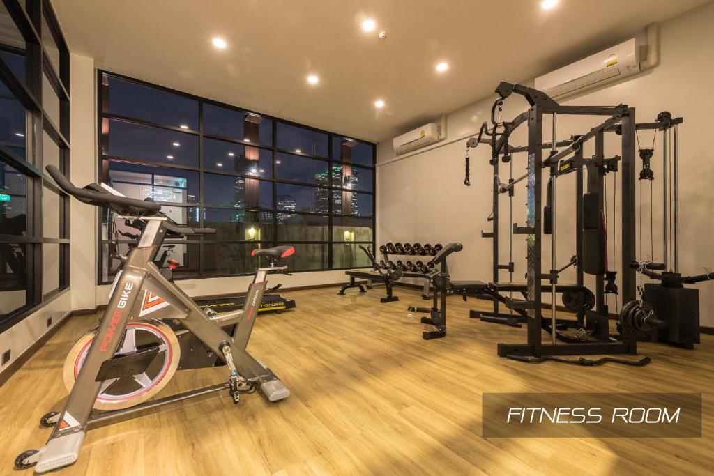 A bright fitness room with cardio equipment, free weights and a cable station.