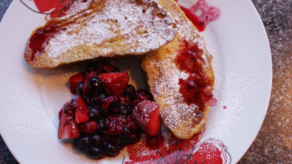 a white plate with toast and fruit on it at Anchor Down Bed & Breakfast in Picton