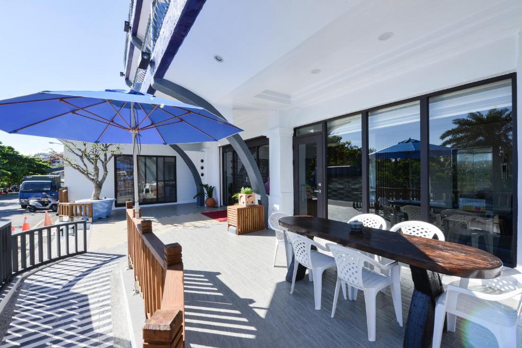 a patio with a table and chairs and an umbrella at Kenting Coast Resort in Kenting