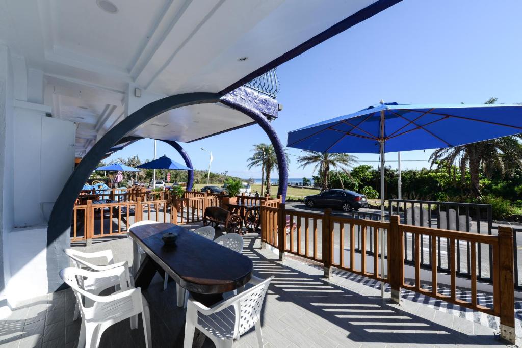 a patio with a table and chairs and an umbrella at Kenting Coast Resort in Kenting