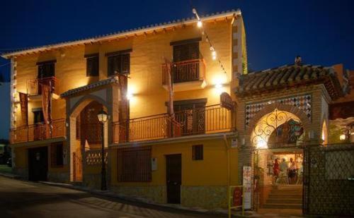 ein großes gelbes Gebäude mit Balkonen auf einer Straße in der Unterkunft Hospedería Ruta de Lorca in Alfacar