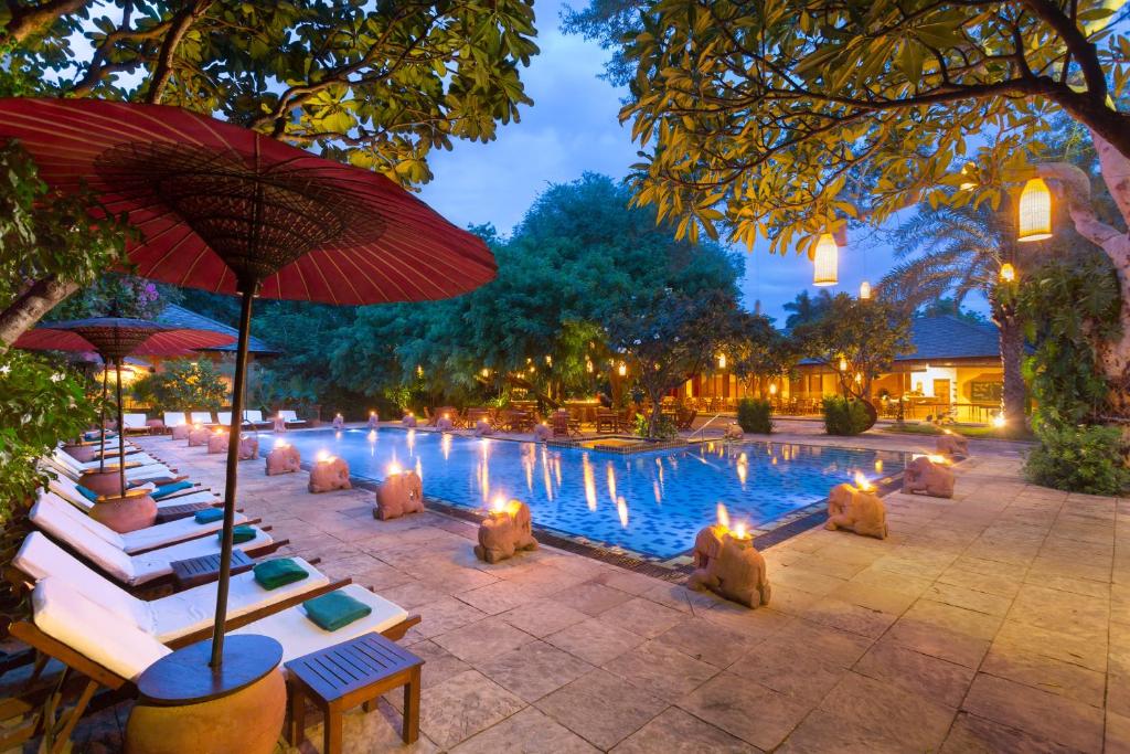 basen z leżakami i parasolami przed nim w obiekcie The Hotel @ Tharabar Gate w mieście Pagan