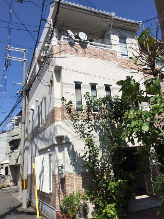 a white building with a fan on the side of it at Ryokoheya Hankyukan in Osaka