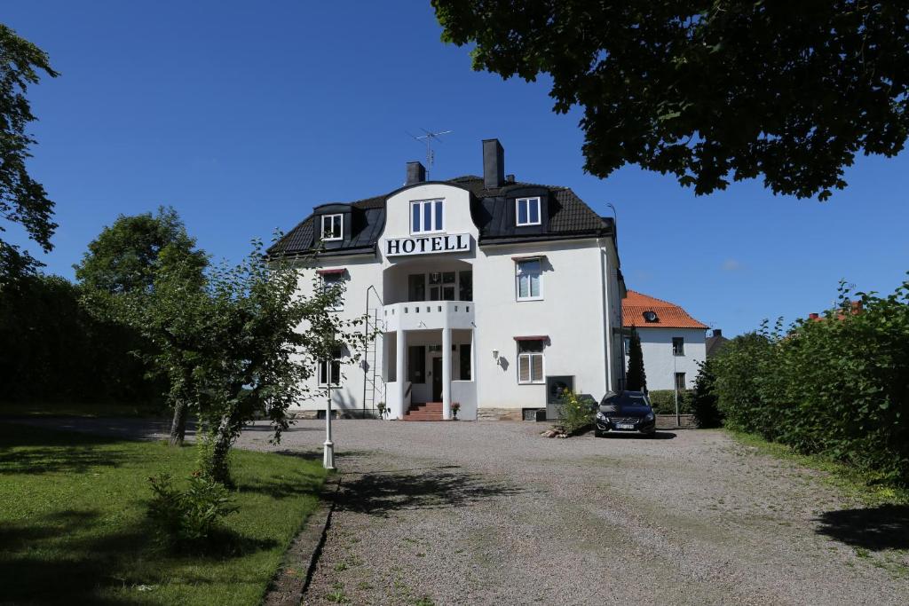 un gran edificio blanco con un cartel. en Hotell S:t Olof, en Falkoping