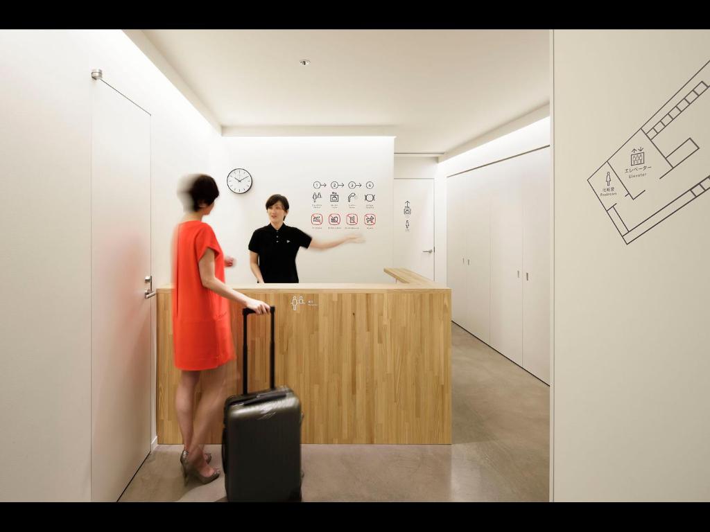 a man and a woman standing at a counter at 9h nine hours woman Kanda in Tokyo