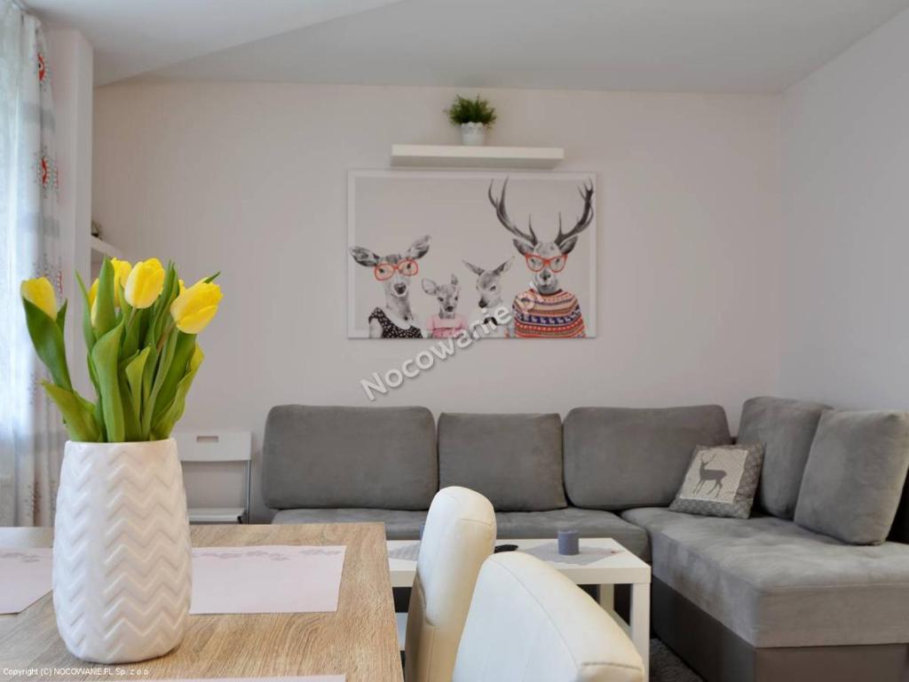 een woonkamer met een bank en een tafel bij Admi Zakopane in Zakopane