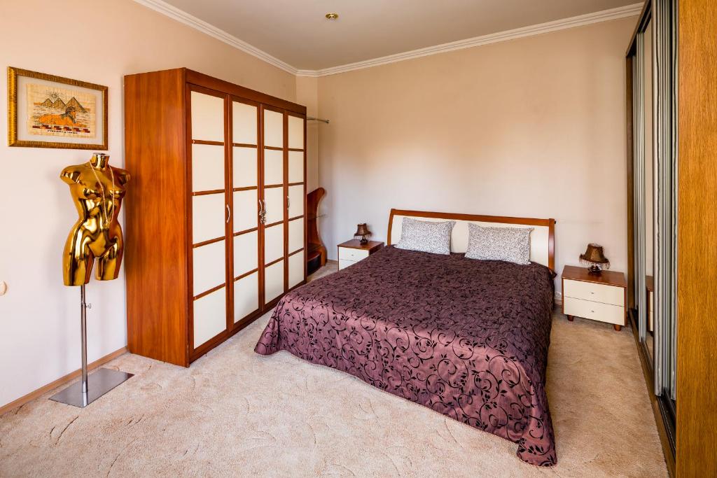 リヴィウにある31 Svobody Avenue Apartmentのベッドルーム1室(紫色のベッドカバー付)