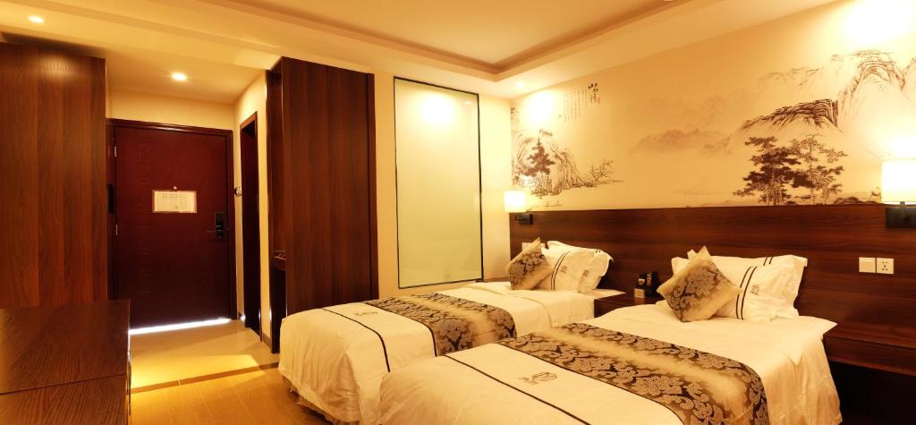 a hotel room with two beds and a mirror at Dmall Hotel in Kigali