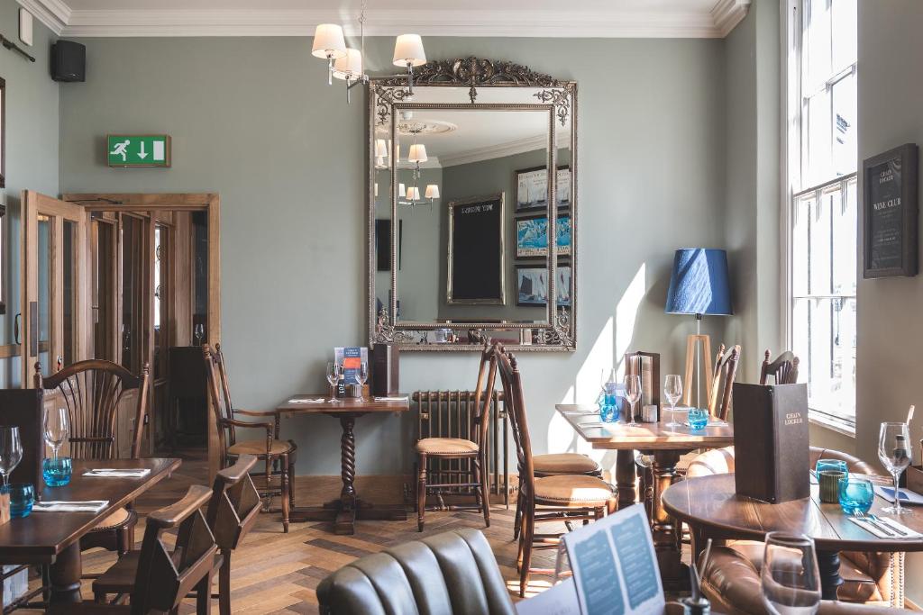 a restaurant with tables and chairs and a mirror at Chainlocker in Falmouth