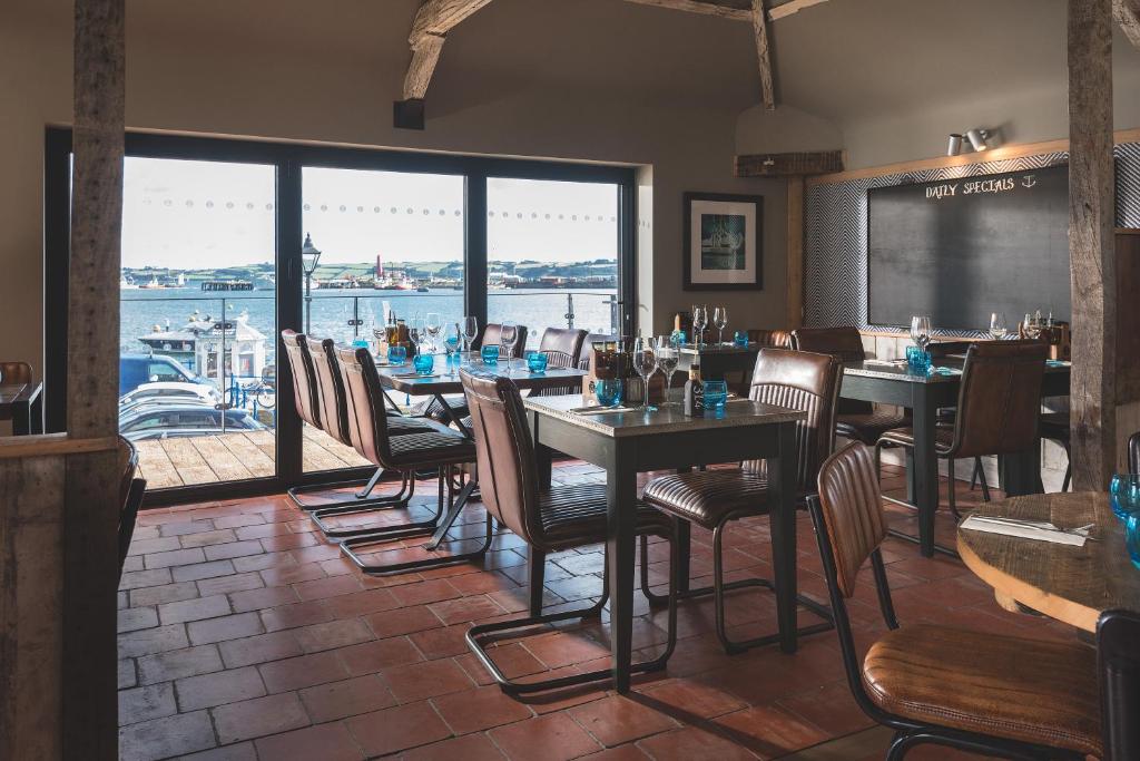 a restaurant with tables and chairs and a view of the water at Chainlocker in Falmouth