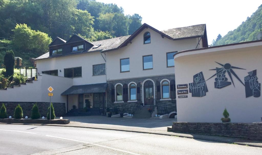 ein weißes Haus mit einer nebenstehenden Windmühle in der Unterkunft Haus am Hang in Bernkastel-Kues