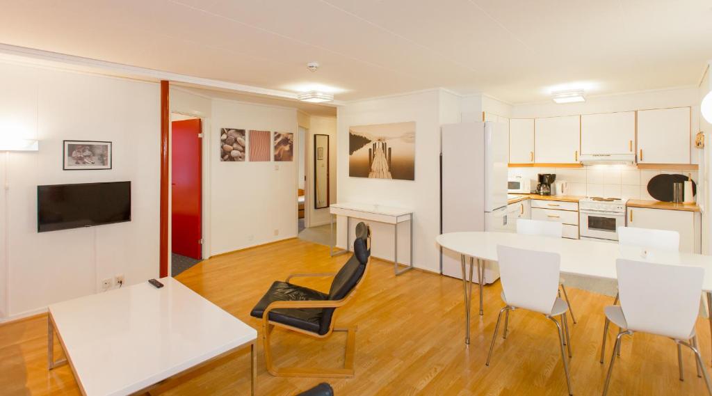 a kitchen and living room with a table and chairs at Sjøsanden Ferietun in Mandal