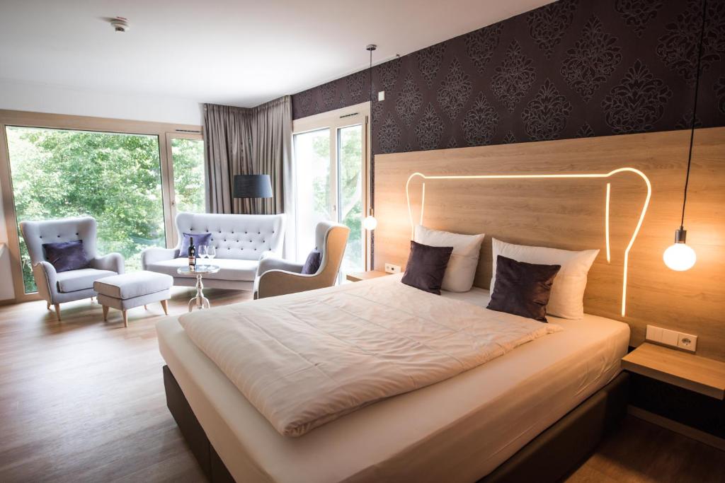 a bedroom with a large bed and a living room at Parkhotel Schillerhain in Kirchheimbolanden