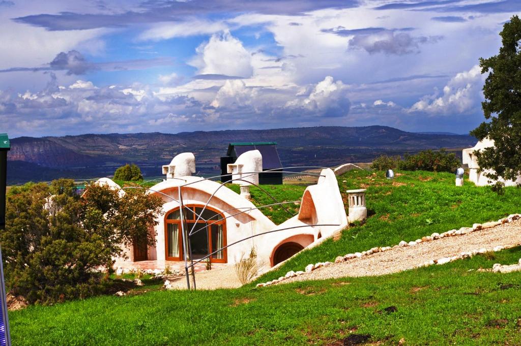 una casa in cima a una collina con erba verde di Hotel Rural & Spa Las Nubes ad Albalate de Zorita