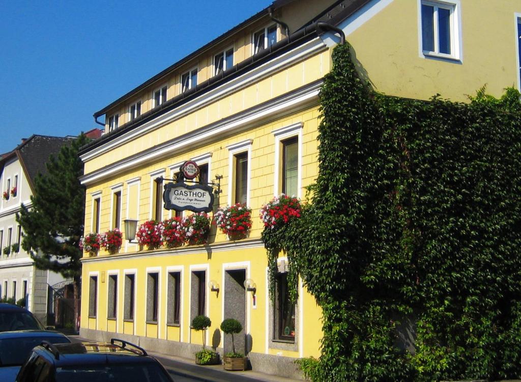 a yellow building with flower boxes on it at Gasthof Manner in Perg