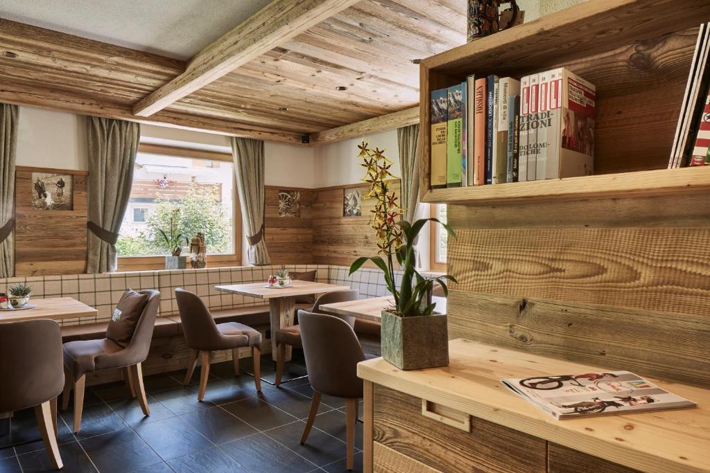 a restaurant with wooden walls and tables and chairs at Hotel Rezia in La Villa