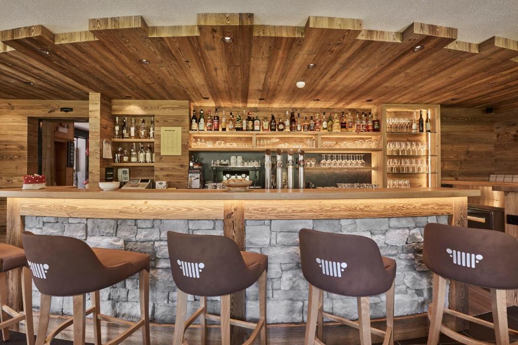 a bar in a restaurant with five chairs at Hotel Rezia in La Villa