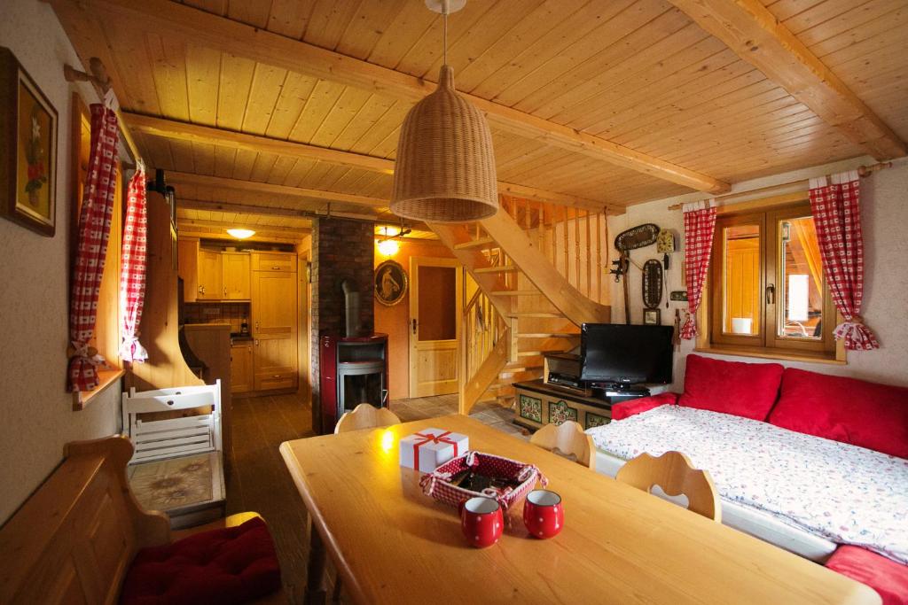 una sala de estar con sofá y mesa en una cabaña en Cosy Chalet on Pokljuka - Brunarica Tinkara, en Zgornje Gorje