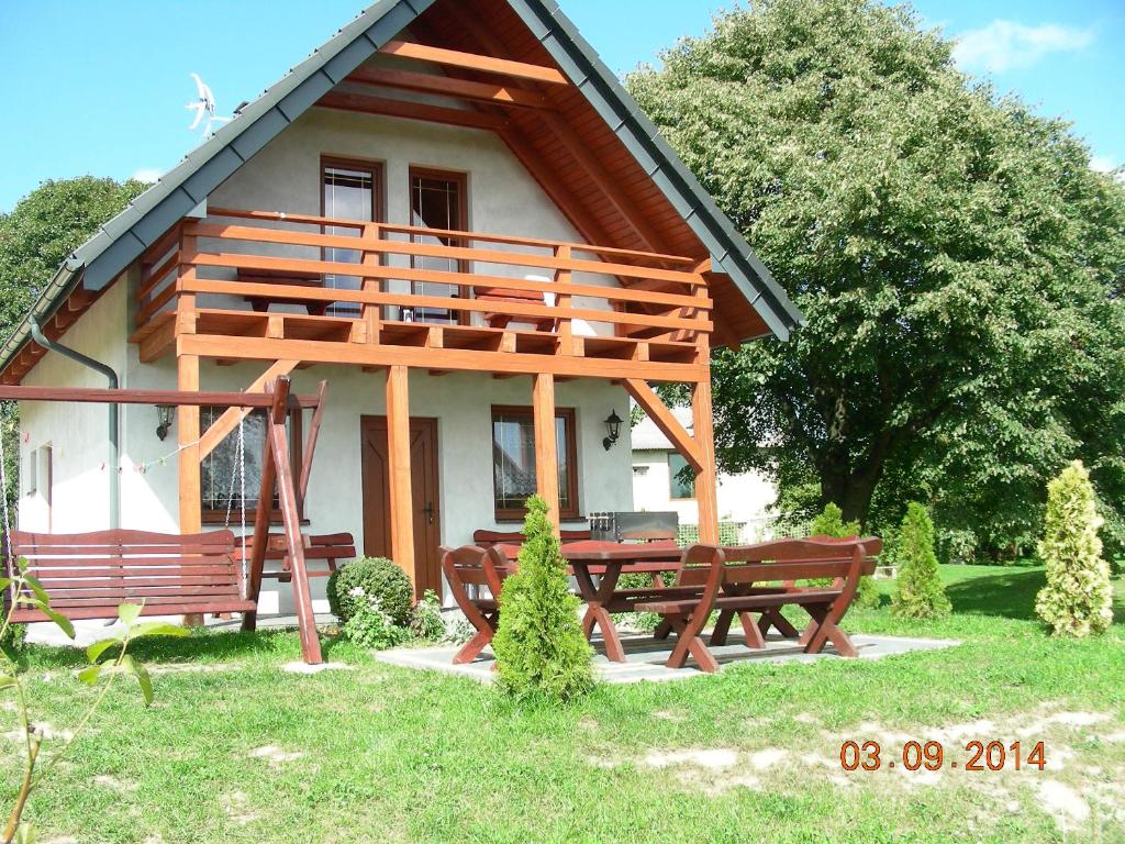 a house with a picnic table and benches in front of it at Choszczogród in Sierakowice