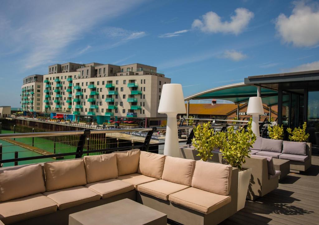 a couch on a balcony with a building in the background at Malmaison Brighton in Brighton & Hove