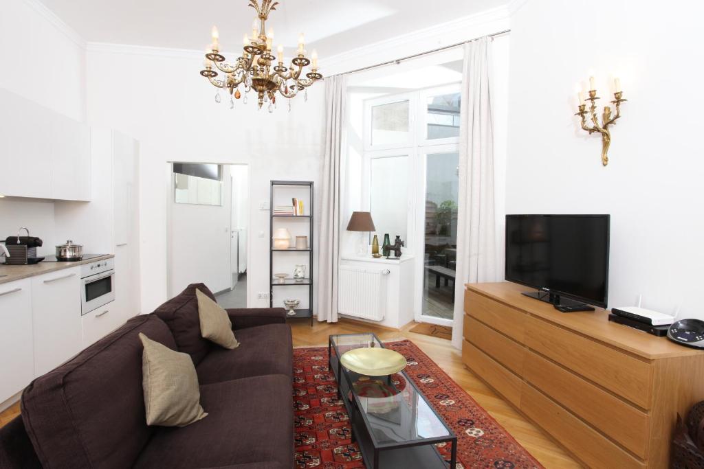 sala de estar con sofá y TV en Hoheschule Apartment Courbette, en Viena