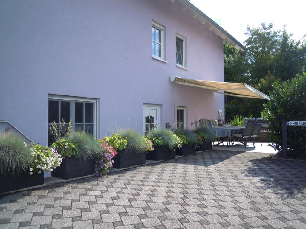 Cette maison blanche dispose d'une terrasse avec une table et des chaises. dans l'établissement Ferienwohnung Wilpert, à Schwanfeld