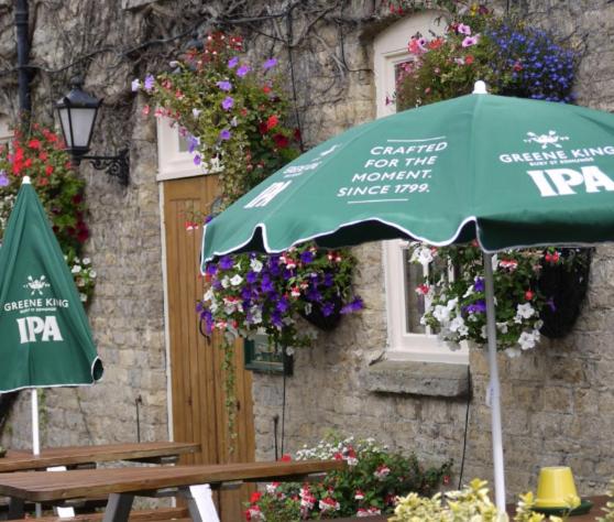 a green umbrella in front of a building with flowers at The Bell Inn in Oxford