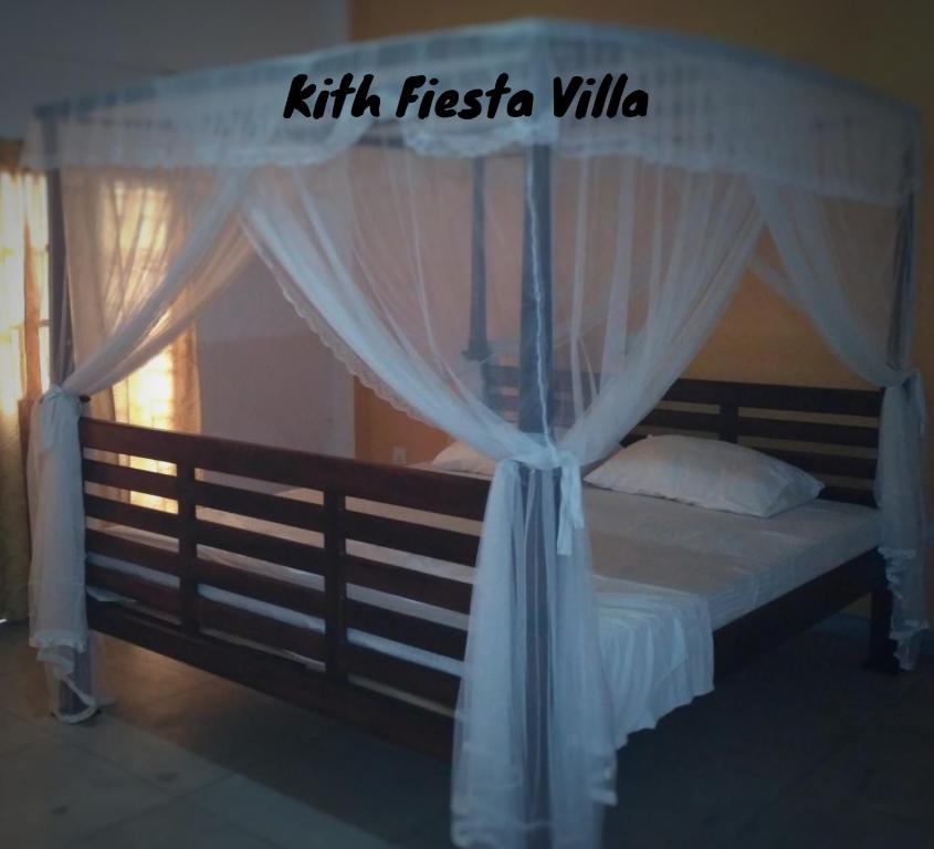 1 dormitorio con cama con dosel y cortinas blancas en Kith Fiesta Villa, en Hikkaduwa