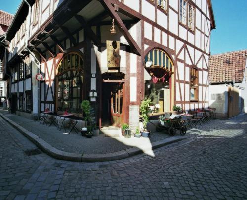 ein Gebäude in einer Kopfsteinpflasterstraße mit Tischen und Bänken in der Unterkunft Himmel & Hölle in Quedlinburg