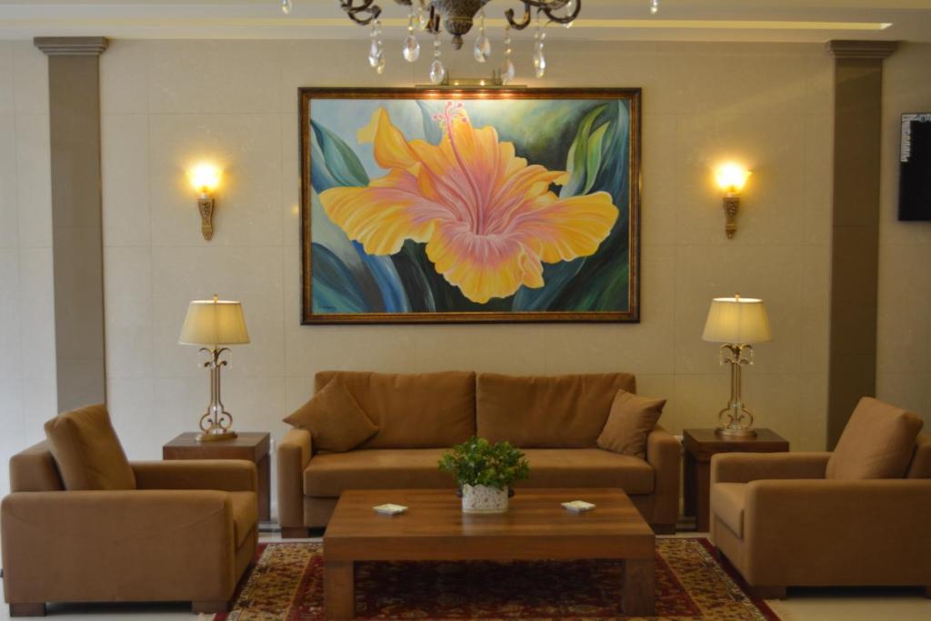 فندق بيلا روزا في بيروت: غرفة معيشة مع اريكة ولوحة ورد