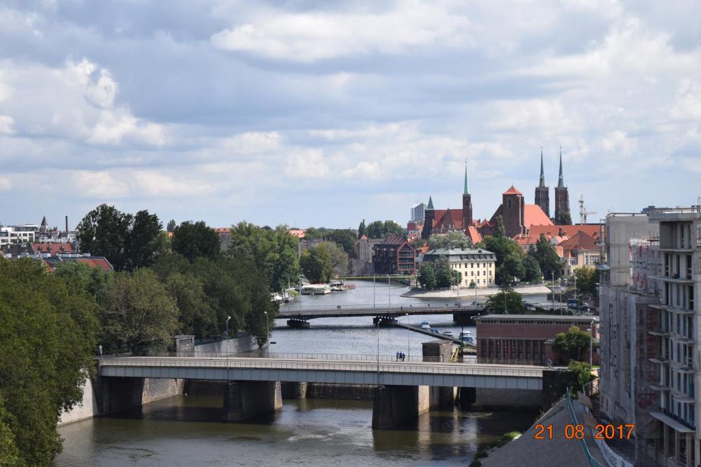 a bridge over a river with a city in the background at Apartment Ksiecia Witolda 43 in Wrocław