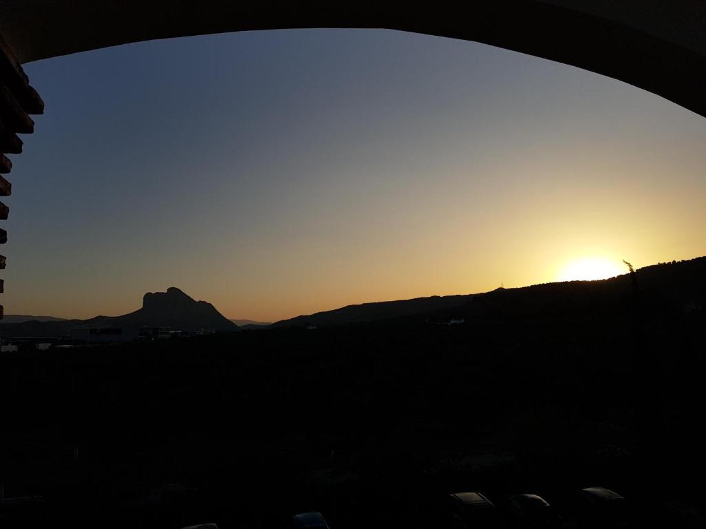 a sunset seen through the window of a building at Los Dólmenes in Antequera
