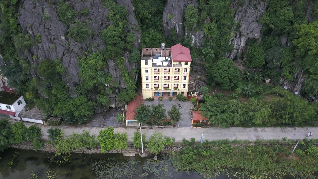 a large building with a red roof on a mountain at Tam Cốc Anna Thắm Hotel in Ninh Binh